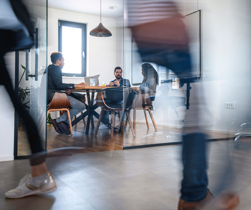 Workspace Workspace with table and three people having a discussion